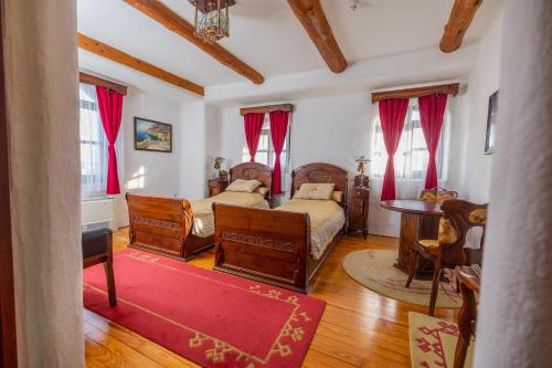 een slaapkamer met 2 bedden en een tafel bij Etno selo Stanišići Hotel Pirg in Dvorovi