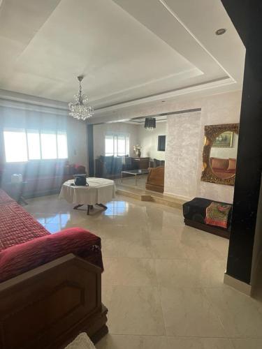 Sala de estar amplia con cama y mesa en Appartement spacieux à seulement 10minutes de la plage d'Agadir en Agadir