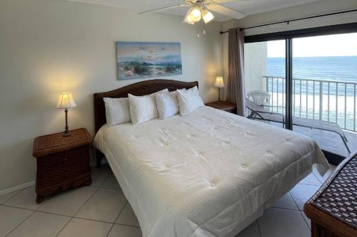 a bedroom with a bed with a view of the ocean at Commodore 1002 in Panama City Beach