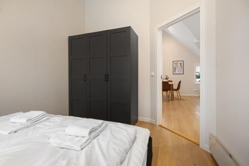 a bedroom with a black cabinet and a bed at Unique and Spacious Apt close to City Centre in Stavanger