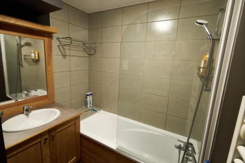 a bathroom with a tub and a sink and a shower at Le Col Roulé in Valloire