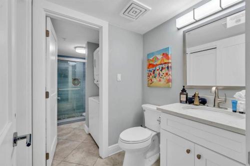 a white bathroom with a toilet and a sink at Gulf Dunes 305 Coastal Dream in Fort Walton Beach