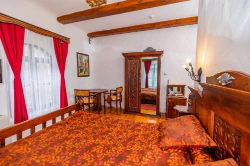 a bedroom with a bed and a table at Etno selo Stanišići Hotel Pirg in Dvorovi