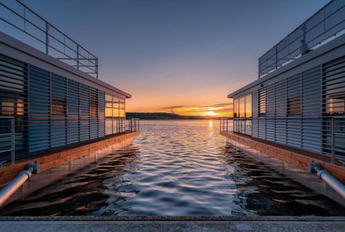 a sunset over the water between two buildings at Hausboot Hering - LP7 in Höxter