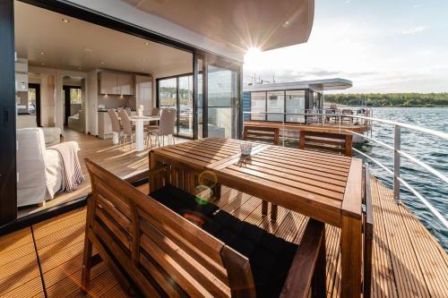 a wooden deck of a boat with a dining table at Hausboot Hering - LP7 in Höxter