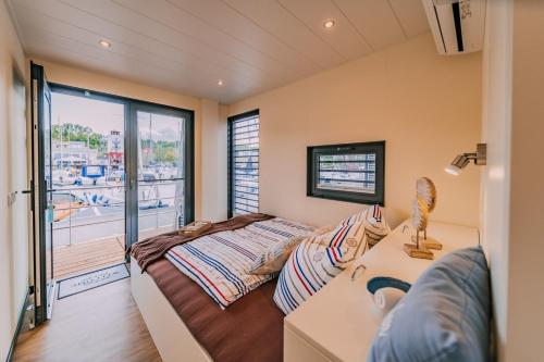 a bedroom with a bed and a balcony at Hausboot Hering - LP7 in Höxter