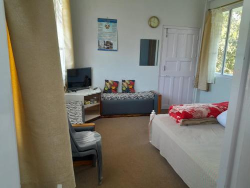 a bedroom with a bed and a chair and a desk at Shanti Sojourn in Shillong
