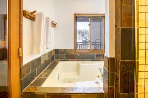 e bagno con finestra e vasca. di Stunning Summit Condo with Sauna, Hot Tub, Pickleball a Sun Valley