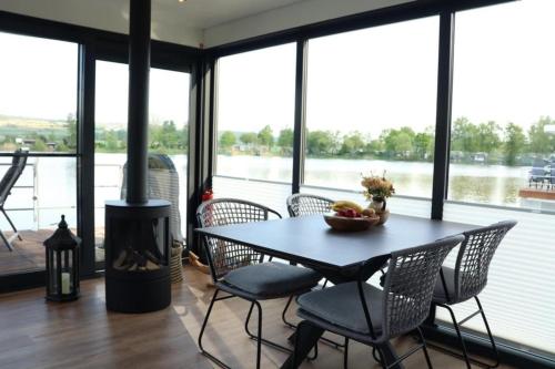 a dining room with a table and chairs and a fireplace at Hausboot CALIENE - LP9 in Höxter