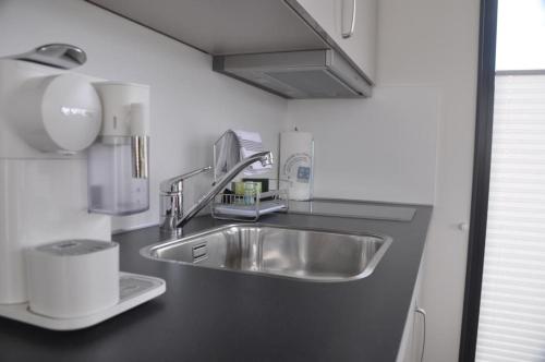 uma cozinha com um lavatório de aço inoxidável numa cozinha em Hausboot Scarlett - LP5 em Höxter