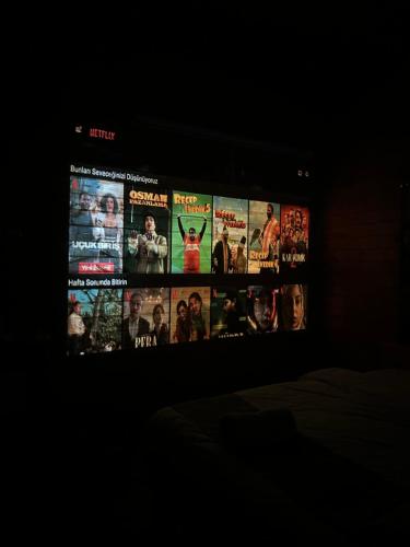 a television screen with many movie posters on it at AYDER BUNGALOW - river view , Royal Bungalow Resorts in Çamlıhemşin