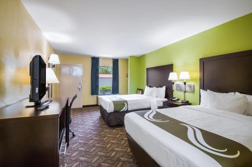 a hotel room with two beds and a flat screen tv at Quality Inn Fredericksburg-Central Park Area in Fredericksburg