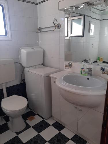 a white bathroom with a toilet and a sink at Suburbs Georgia's loft in country side 15' from the Airport in Paianía