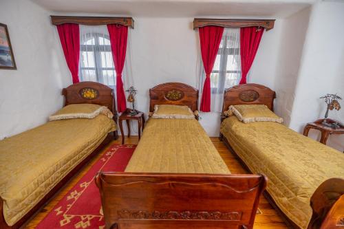 two beds in a room with red curtains at Etno selo Stanišići Hotel Pirg in Dvorovi