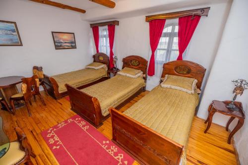a room with four beds and a table and chairs at Etno selo Stanišići Hotel Pirg in Dvorovi
