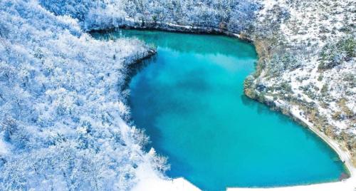 an aerial view of a blue lake in the snow at B&B I Giardini in Pieve Torina