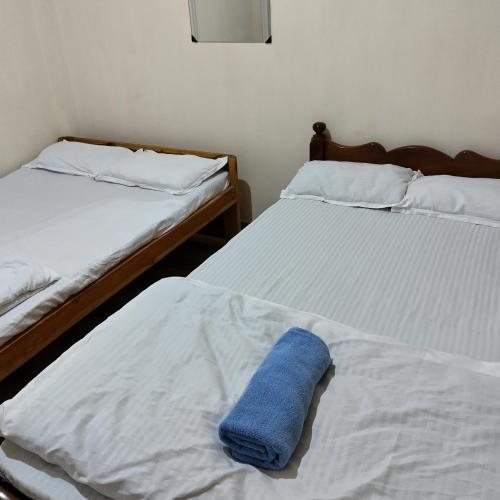 a blue towel laying on two beds in a room at Shanti Sojourn in Shillong