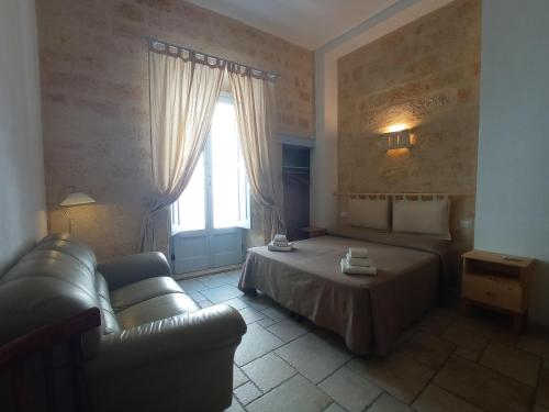 a bedroom with a bed and a couch and a window at Bed & Breakfast Casa Lopez in Barletta