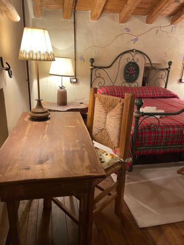 a bedroom with a table and a bed with a lamp at Alloggio La Torre Fossanova in Priverno