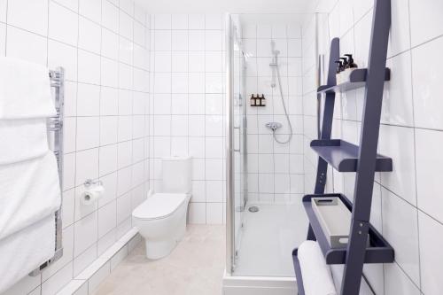 a white bathroom with a shower and a toilet at SACO Jersey - Merlin House in Saint Helier Jersey