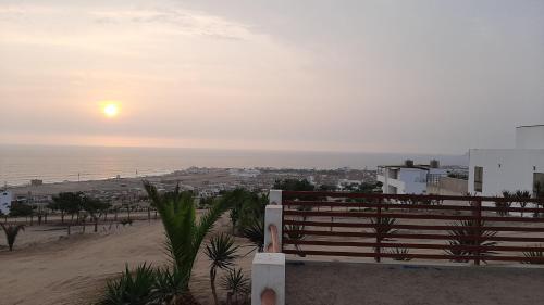 a bench on the beach with the sunset in the background at CASA DE PLAYA Durante todo el año in Punta Negra