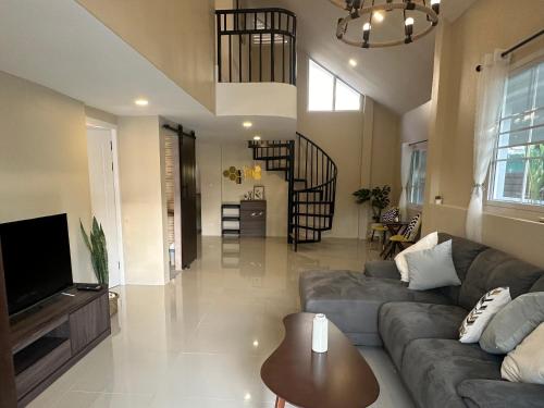 a living room with a couch and a tv at Luxury Thai Escape in Chiang Mai