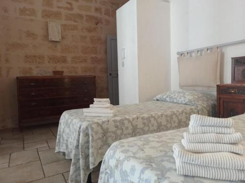 a bedroom with two beds and a dresser at Bed & Breakfast Casa Lopez in Barletta