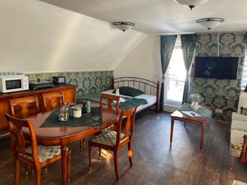 a living room with a table and a bed at Ubytování U Synagogy Dobříš in Dobříš