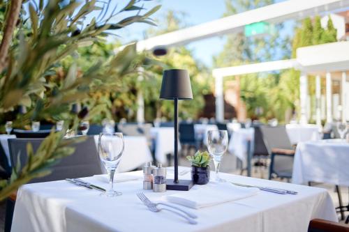 a table with white table cloth and wine glasses on it at Hotel Bessunger Forst in Roßdorf