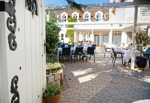 a patio with tables and chairs in a restaurant at Hotel Bessunger Forst in Roßdorf