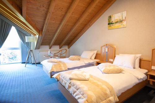a bedroom with two beds in a room at Hotel Bessunger Forst in Roßdorf