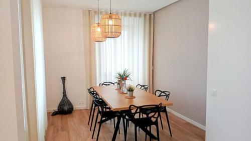 a dining room with a wooden table and black chairs at SurfSoul Guesthouse - Bed and Breakfast in Peniche