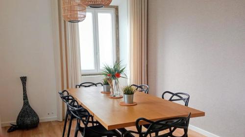 een eettafel met stoelen en een raam bij SurfSoul Guesthouse - Bed and Breakfast in Peniche