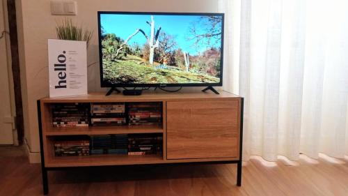 a flat screen tv sitting on top of a wooden entertainment center at SurfSoul Guesthouse - Bed and Breakfast in Peniche