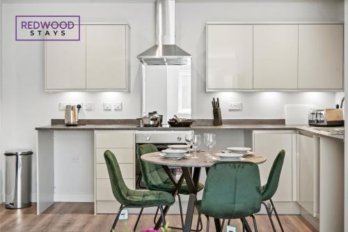 cocina con mesa y sillas verdes en Quality 1 Bed 1 Bath Apartments For Contractors By REDWOOD STAYS, en Farnborough