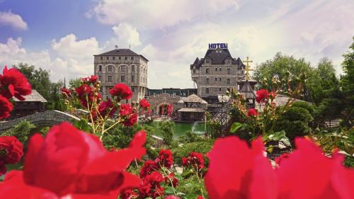 a view of a building with flowers in the foreground at Etno selo Stanišići Hotel Pirg in Dvorovi