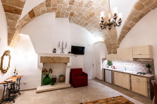 a kitchen with an arched ceiling and a red chair at Palazzo dei Don in Racale