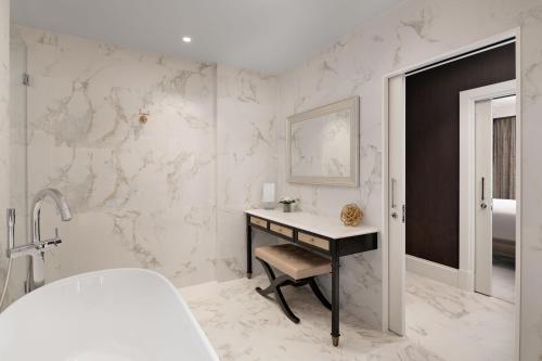 a white bathroom with a desk and a sink at Fairmont Windsor Park in Windsor