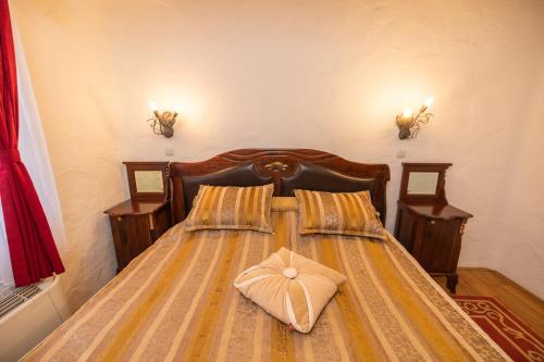 a bedroom with a bed with a pillow on it at Etno selo Stanišići Hotel Pirg in Dvorovi