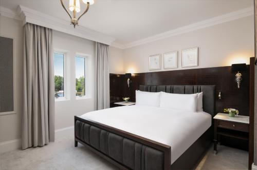 a bedroom with a large white bed and a window at Fairmont Windsor Park in Windsor