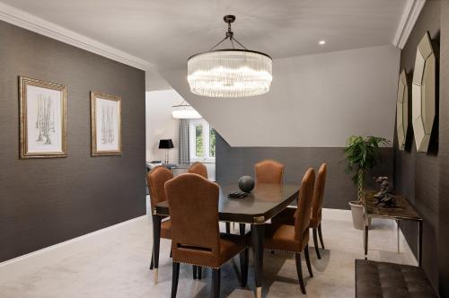a dining room with a table and chairs at Fairmont Windsor Park in Windsor