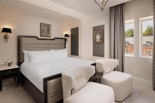 a bedroom with a bed and two chairs at Fairmont Windsor Park in Windsor