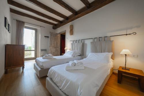 リッツァーノ・イン・ベルヴェデーレにあるBorgo Pianello Country Resortのタオルが敷かれたベッドが2つある寝室