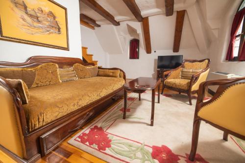 a living room with a couch and a table and chairs at Etno selo Stanišići Hotel Pirg in Dvorovi