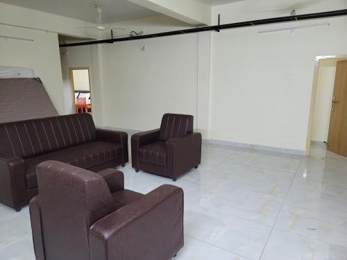 een wachtkamer met 2 stoelen en een bank bij Hotel Deepak Retreat in Gudivāda
