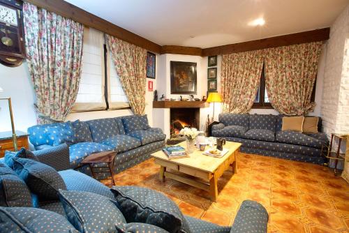 uma sala de estar com sofás azuis e uma mesa em Complejo Rural Victory em Cuenca