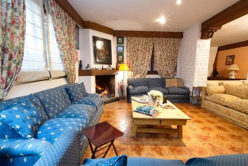 クエンカにあるHotel Rural Victoria by Bossh! Hotelsの青いソファと暖炉のあるリビングルーム