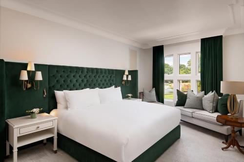 a bedroom with a large white bed and a green wall at Fairmont Windsor Park in Windsor