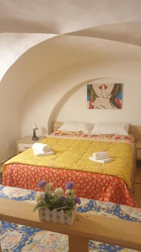ein Schlafzimmer mit einem Bett mit gelber Tagesdecke in der Unterkunft Home Hostel Catania in Catania