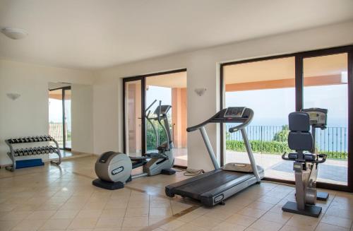 a gym with treadmills and exercise equipment and windows at Kaliakria Resort in Topola